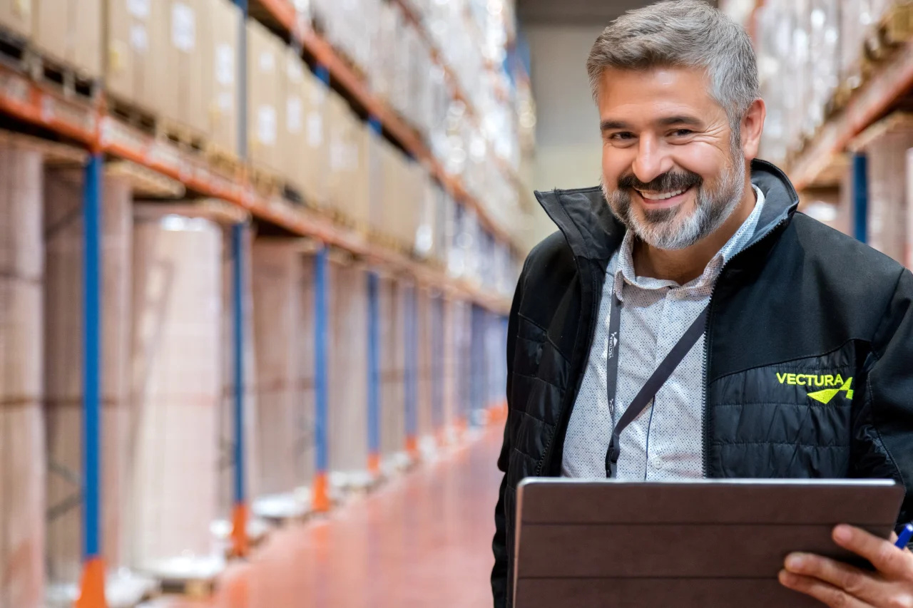 Responsable Vectura Logistique supervisant les opérations d’entrepôt avec tablette numérique
