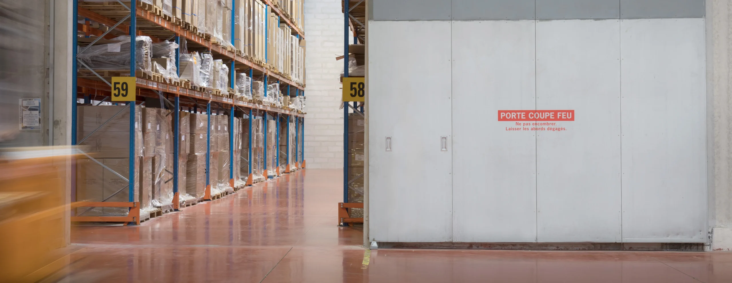 Entrepôt logistique sécurisé avec porte coupe-feu et zone de stockage grande hauteur