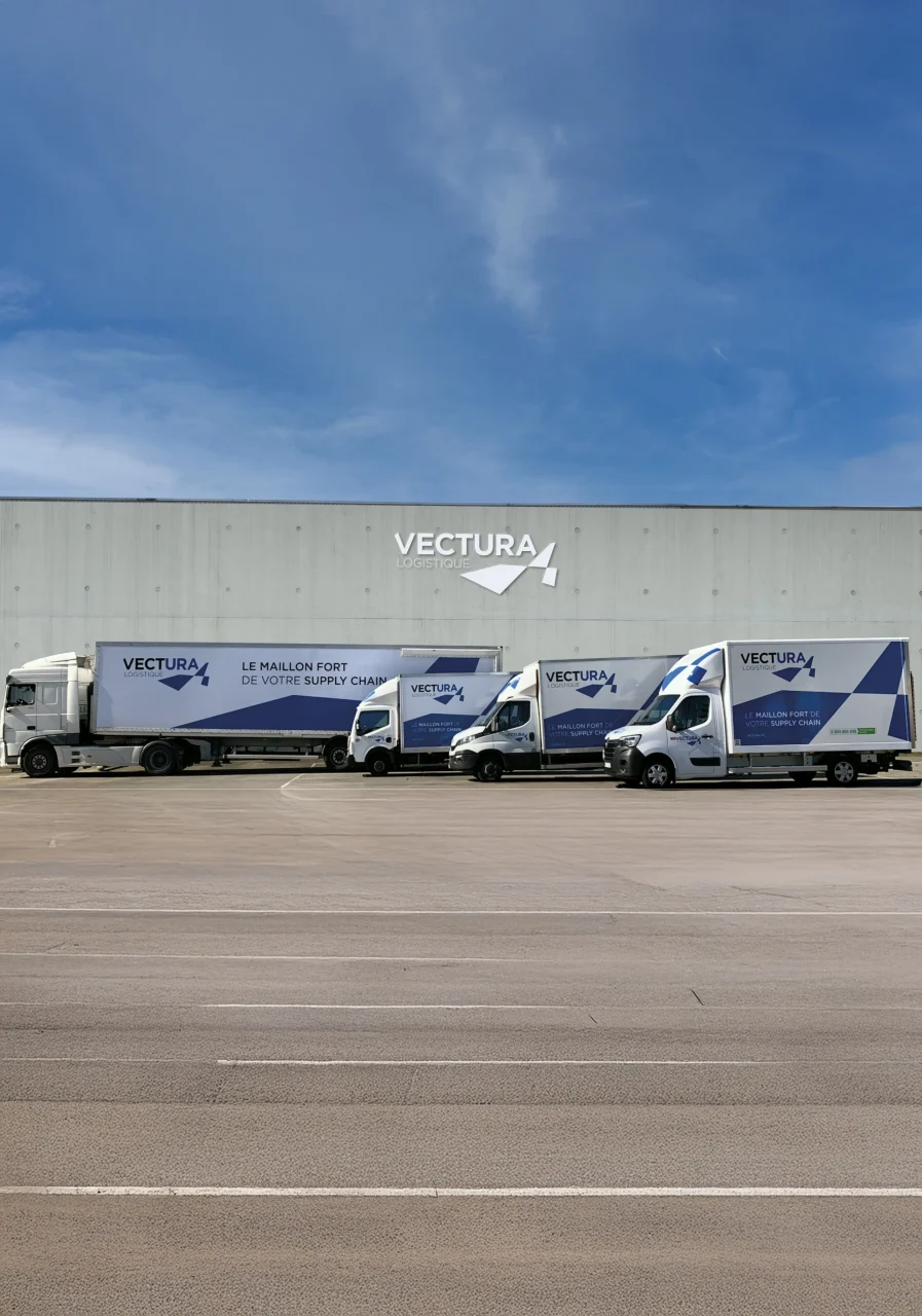 Flotte de camions et utilitaires Vectura Logistique alignés devant une plateforme logistique