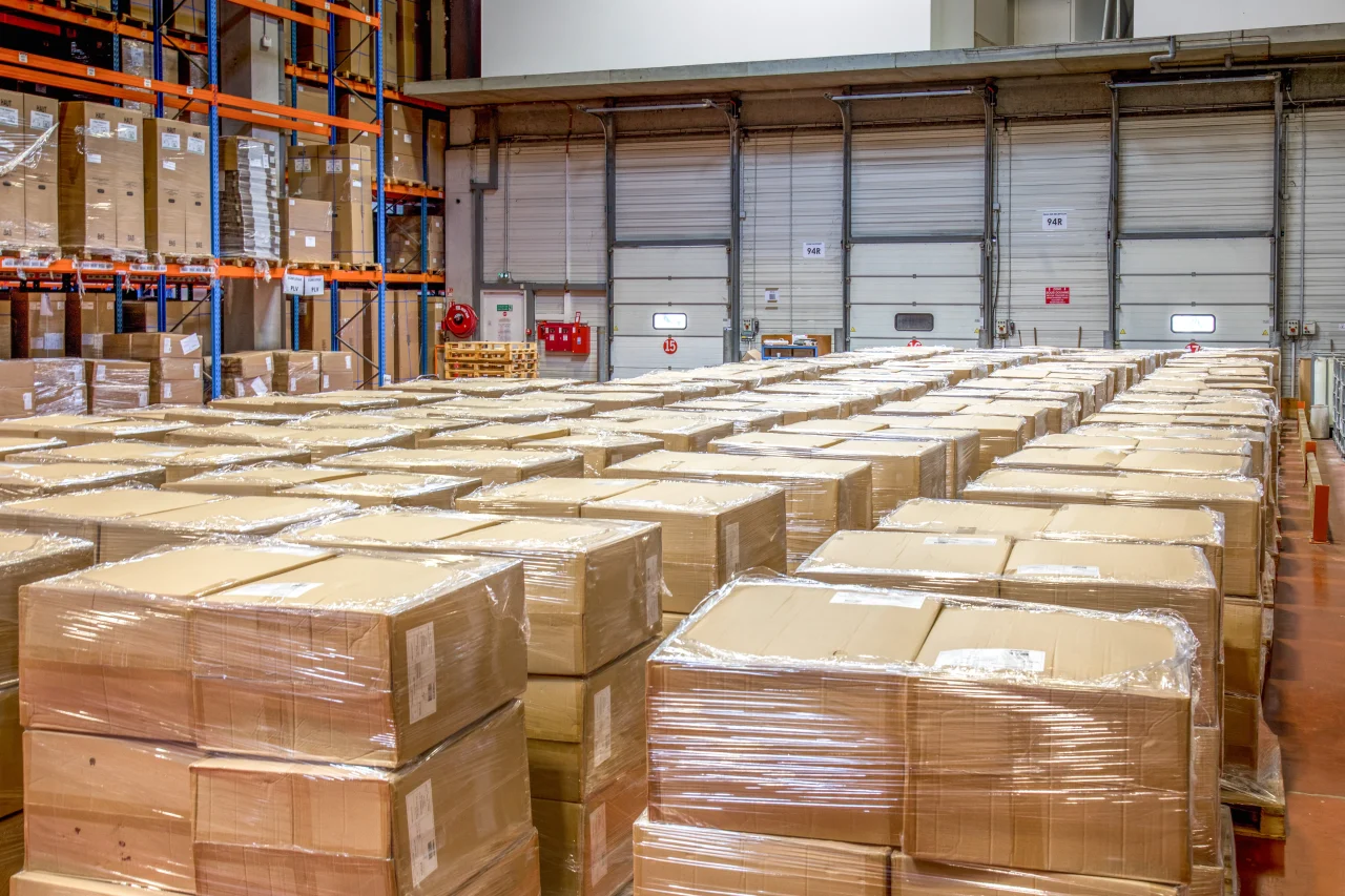 Zone de préparation de commandes et d’expédition avec palettes filmées prêtes au départ